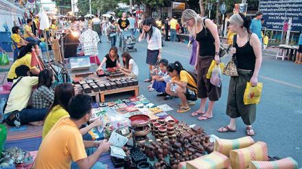 Anders leben. In Chiang Mai besuchen europäische Frauen einen Straßenmarkt und genießen ein Stück Freiheit von Beruf und Alltag. 