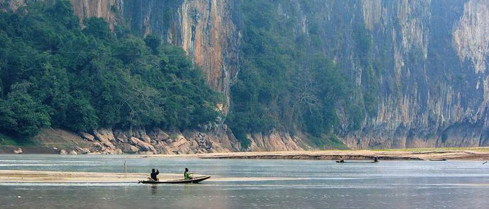 Abhang. Steile Felsen und grüne Hügel prägen die Ufer des Mekong.