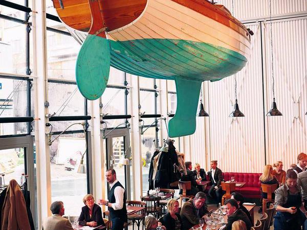 Auftischen. Im Restaurant „Oaxen“ speisen Gäste unter Schiffsrümpfen und mit Panoramablick aufs Wasser.