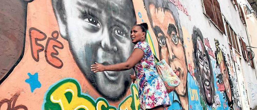 Die Verlorenen. Paloma Novae vor einem Bild ihres getöteten Sohnes. Die Graffiti zeigen Opfer von Querschlägern.