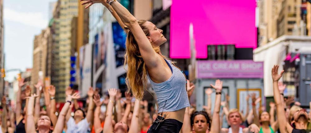 Massen-Yoga. Jedes Jahr treffen sich tausende Yoga-Fans zum Sommeranfang auf dem New Yorker Times Square.