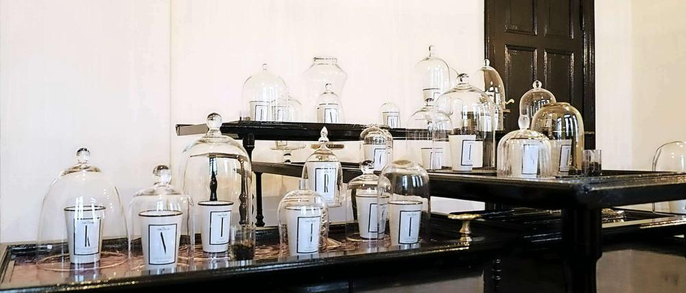 Unter der Haube. Glasglocken verhindern ein Duftchaos. Die Tische im Atelier Oblique ließ Mario Lombardi aus alten Türen bauen.