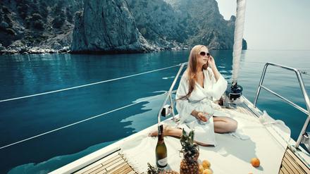 Luxusurlaub auf einer Yacht, mit Weinflasche und exotischen Früchten.