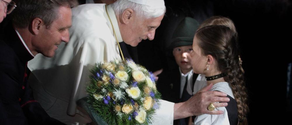 Papst Benedikt XVI zu Besuch in Bayern im Jahr 2006 mit einem Mädchen in Landestracht.