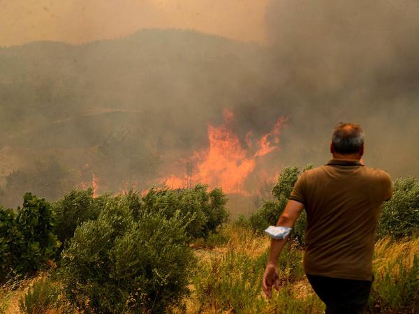 Ein Mann steht in der Nähe von Manavgat vor den lodernden Flammen.