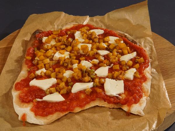 Bevor der Belag und die Tomatensauce aufgetragen werden, wird der Pizzateig kurz vorgebacken, so wird er knuspriger - Geschmackssache.