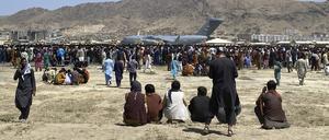 Menschen versammeln sich in der Nähe eines C-17-Transportflugzeugs der US-Luftwaffe auf dem Gelände des internationalen Flughafens in Kabul (Archivbild).