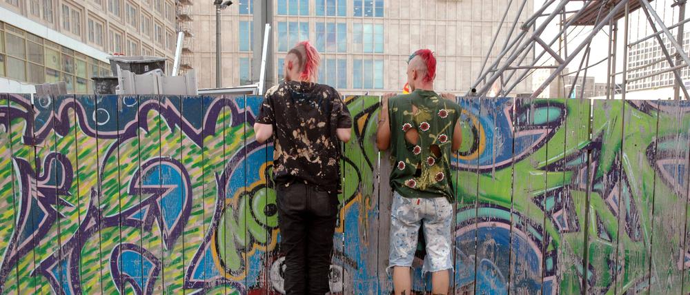 Zaungäste der modernen Stadtplanung: Zwei Punker schauen sich eine Berliner Baustelle an.