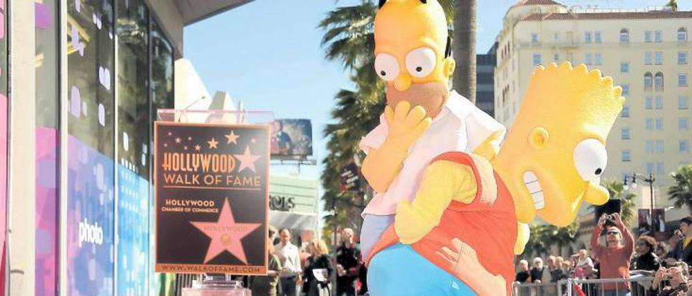 Homer und Bart Simpson machen sich darüber lustig, dass ihr Erfinder Matt Groening einen Stern auf dem „Walk of Fame“ in Hollywood bekommt. 