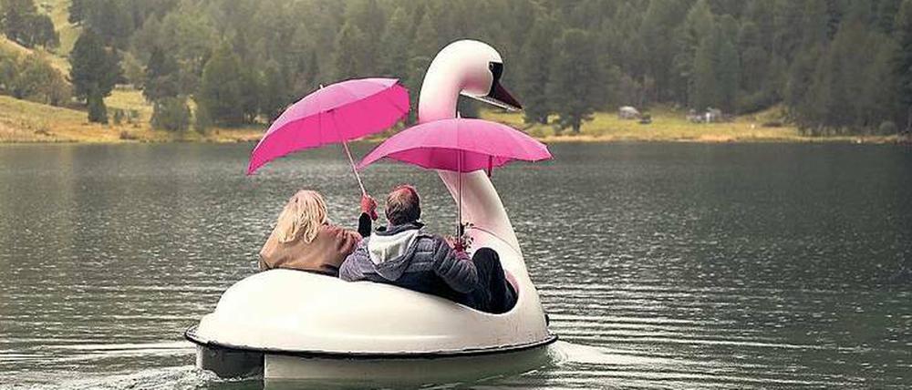 Da geht was. Astrid und Rolf lassen sich auch nicht vom Regen und pinken Schirmen von der Fahrt im Schwanen-Tretboot abhalten.