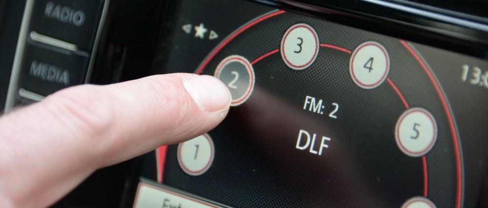 Ein Mann stellt in einem Auto den Radiosender "Deutschlandfunk" ein.