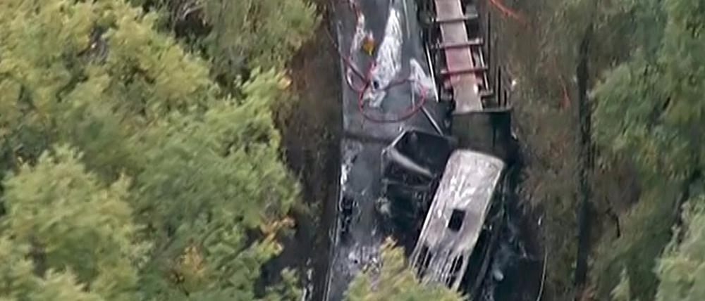 Die Luftaufnahme des Unglücksortes nahe Bordeaux zeigt einen Holztransporter (oben) und den völlig ausgebrannten Bus. Bei dem Unglück kamen 42 Menschen ums Leben. 
