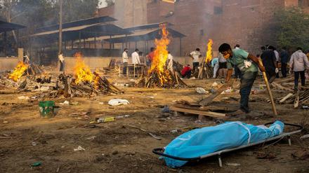 Flammende Zeichen. Scheiterhaufen brennen in Neu-Delhi über Leichnamen von Coronavirus-Opfern.