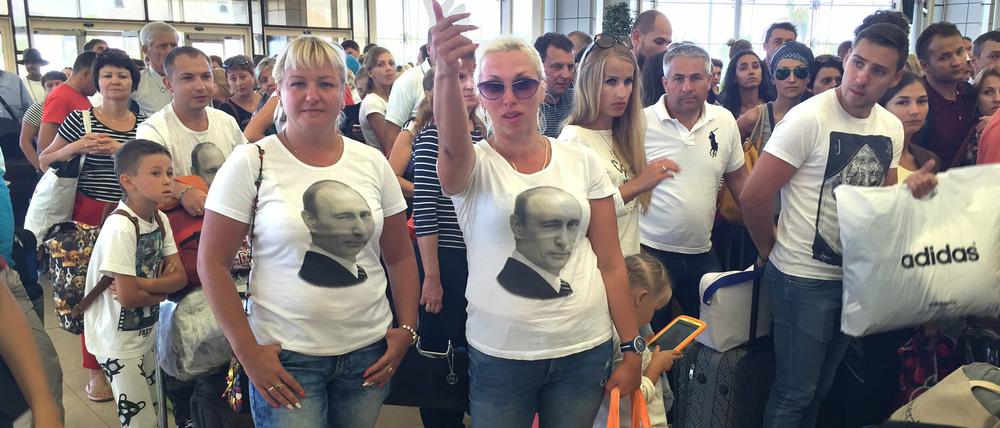 Zwei Frauen mit T-Shirt mit einem Porträt von Russlands Präsident Wladimir Putin warten im Andrang vor der Sicherheitskontrolle am Freitag am Flughafen von Scharm el Scheich, Ägypten. Am 04.11. hatte die britische Regierung aus Angst vor Terroranschlägen alle Flüge zwischen dem Urlaubsort am Roten Meer und Großbritannien gestoppt.
