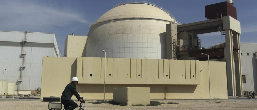 Ein Arbeiter fährt mit seinem Fahrrad vor dem Reaktorgebäude am Atomkraftwerk Buschehr.