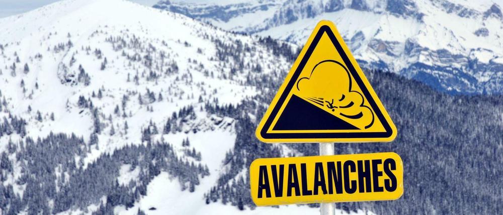 Ein Schild warnt in den Französischen Alpen vor Lawinen. 