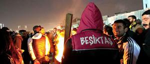 Fußballfans von Besiktas Istanbul wärmen sich während einer Protestversammlung gegen den Prozess gegen ihre Kameraden an einem Feuer.