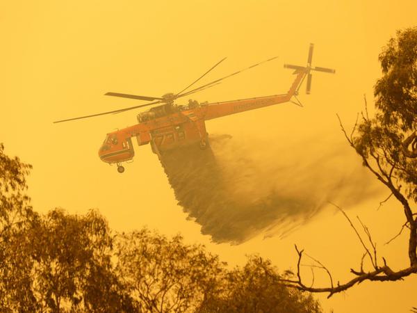 Ein Hubschrauber wirft Wasser auf ein Feuer in der Nähe von Bumbalong ab, südlich der australischen Hauptstadt Canberra. 