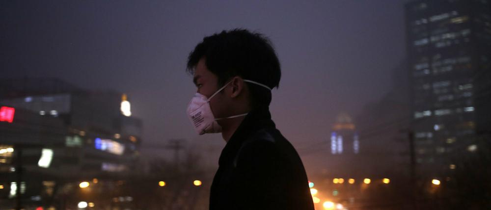 Ein Mann mit Atemmaske im Peking am Dienstag. 