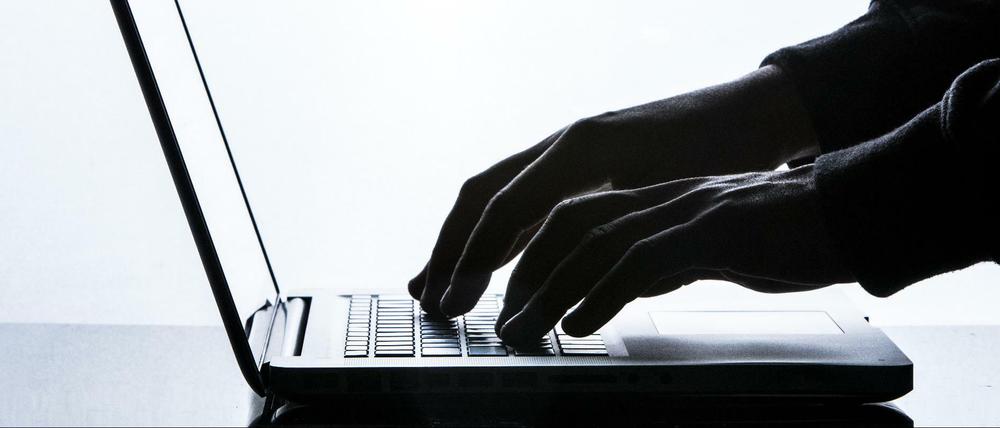 Ein Mann tippt auf einer Tastatur eines Laptops. (Symbolfoto) 