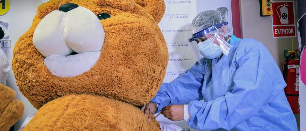 Auf diesem Aufklärungsfoto der peruanischen Regierung wird symbolisch ein Teddybär geimpft.