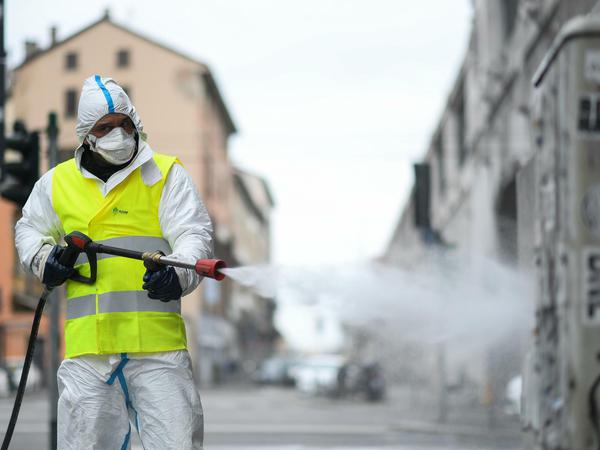 Ein Arbeiter desinfiziert in Mailand die Straßen.