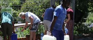 Bürger füllen ihre Wasserkanister an einer natürlichen Quelle in Kapstadts Vorort Newlands auf.