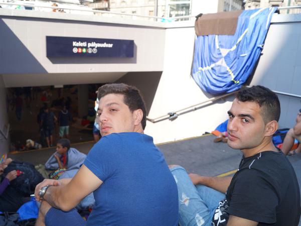 Mohammed und Hisham sitzen stundenlang auf dieser Treppe und warten auf eine Lösung, um nach Deutschland zu fahren. 