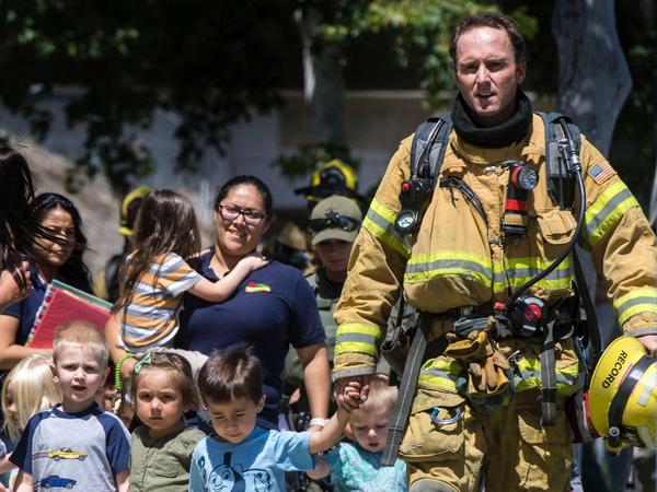 Kinder aus einem Kindergarten werden von Rettungskräften nach einer Explosion in einer Klinik in Sicherheit gebracht. 