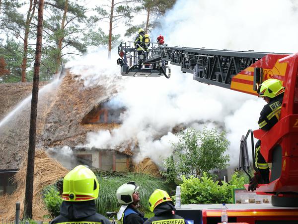 Die Feuerwehr löscht den Brand eines reetgedecktes Ferienhauses auf Usedom. 