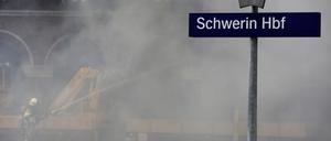Feuerwehrleute löschen einen Brand auf dem Gelände vom Schweriner Bahnhof.