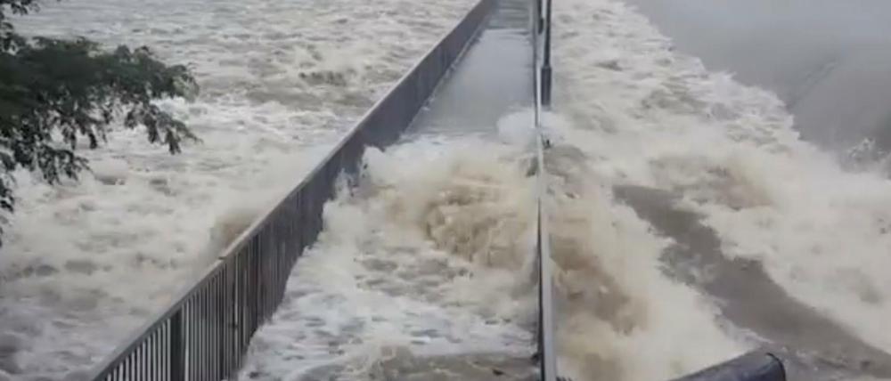 Wassermassen überfluten eine Fußgängerbrücke in Townsville, Queensland.