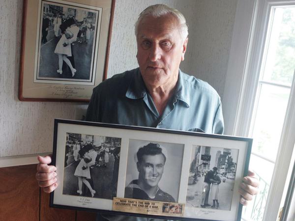 George Mendonsa lässt sich mit alten Fotos von sich fotografieren, u.a. einer Kopie (l) des berühmten Alfred Eisenstadt-Fotos "Küssender Matrose". (Archivbild 2009)