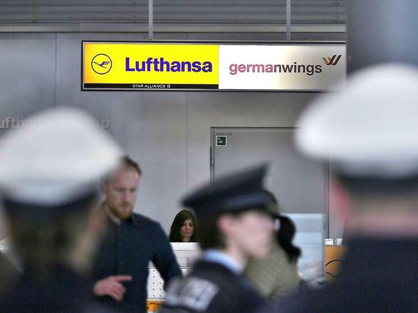 Polizisten stehen am Flughafen Düsseldorf vor einem Germanwings-Schalter.