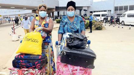 Leben mit Ebola. Zwei Frauen bereiten sich auf dem Flughafen in der nigerianischen Millionen-Stadt Lagos auf ihren Abflug vor. Auch das Sicherheitspersonal tritt derzeit mit Mundschutz und Einmal-Handschuhen seinen Dienst an. 