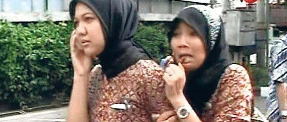 Angst nach dem Beben. Eine Frau in Banda Aceh klammert sich entsetzt an ihre Begleiterin. Das unscharfe Foto wurde vom Bildschirm abfotografiert. 