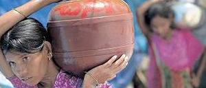 Unerträgliche Hitze. Inderinnen tragen einen Krug Wasser nach Hause. 