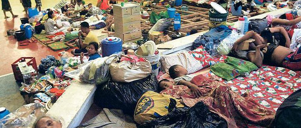 Rechtzeitig in Sicherheit gebracht. Bewohner der Stadt Sorsogon übernachten in einer Turnhalle, die dem Sturm standhalten kann. Der Taifun „Haiyan“ hat große Verwüstungen hinterlassen. Viele Gebiete sind von der Außenwelt abgeschnitten. Foto: dpa