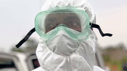 Ganzkörperschutz. Ein Mitarbeiter der Gesundheitsbehörden von Liberia beim Einsatz zur Bergung von toten Ebolaopfern. 