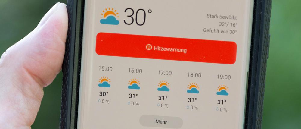 Auf dem Display eines Smartphones wird eine Hitzewarnung für Deutschland vermeldet.(Archivbild)