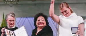 Setsuko Thurlow (M), Hiroshima-Überlebende und Aktivistin der Internationalen Kampagne für die Abschaffung von Atomwaffen (Ican) und Beatrice Fihn (r), Ican-Geschäftsführerin, freuen sich am 10.12.2017 in Oslo (Norwegen) über den Friedensnobelpreis. Links im Bild steht Berit Reiss-Andersen vom Nobelpreis-Komitee. 