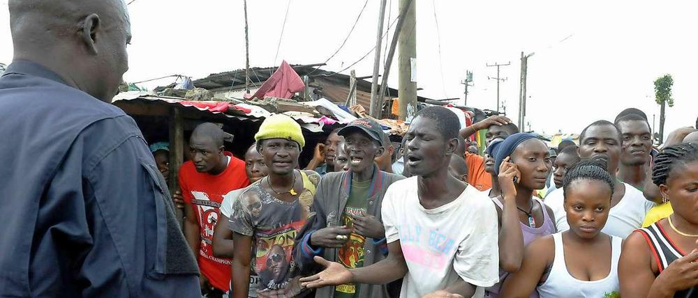 Das Armenviertel West Point in der liberianischen Hauptstadt Monrovia ist unter Quarantäne gestellt worden. Die Einwohner sind nun Gefangene in ihrer eigenen Stadt - und fürchten sich umso mehr vor einer Ansteckung mit Ebola. Hier argumentieren sie mit einem Sicherheitsbeamten, der sie daran hindern soll, den Stadtteil zu verlassen. 