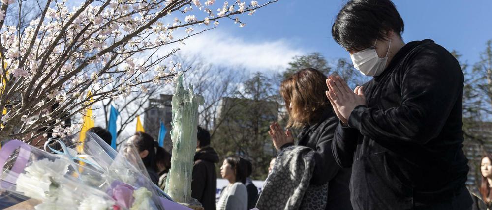 Menschen beten am achten Jahrestag zur Tsunami-Katastrophe im Hibiya-Park