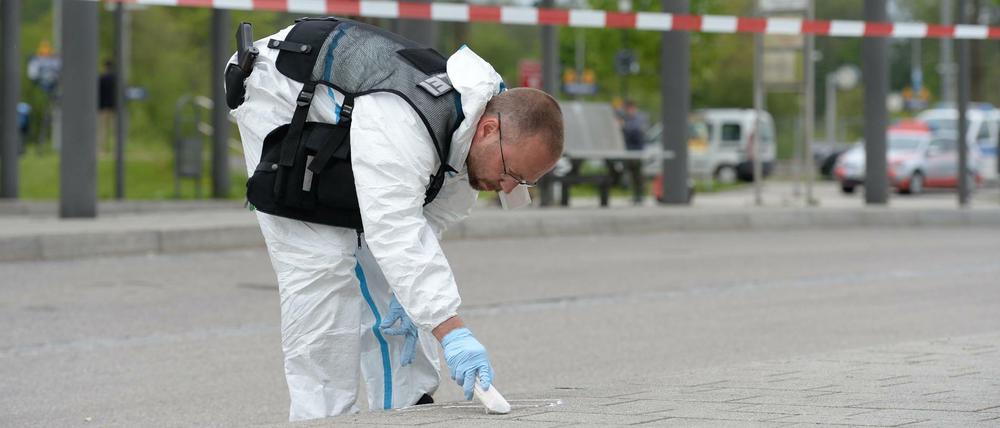 Spurensuche: Ein Ermittler der Polizei macht am Bahnhof in Grafing auf dem Boden eine Markierung. 