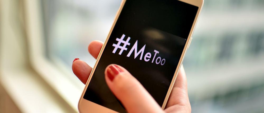Eine junge Frau hält ein Smartphone mit dem Hashtag "MeToo" in der Hand. (Symbolbild)