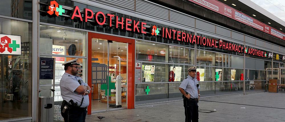 Polizisten stehen vor der Apotheke am Kölner Hauptbahnhof, in der sich am Montag der Geiselnehmer verschanzt hatte.