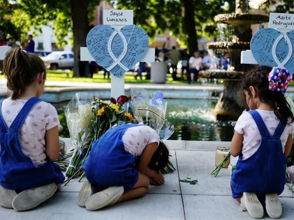 Kinder trauern um die Opfer des Massakers vor Kreuzen, die zum Gedenken an die Opfer aufgestellt wurden. 