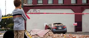 Ein Junge im kalifornischen Napa blickt nach dem schweren Erdbeben auf ein demoliertes Auto.