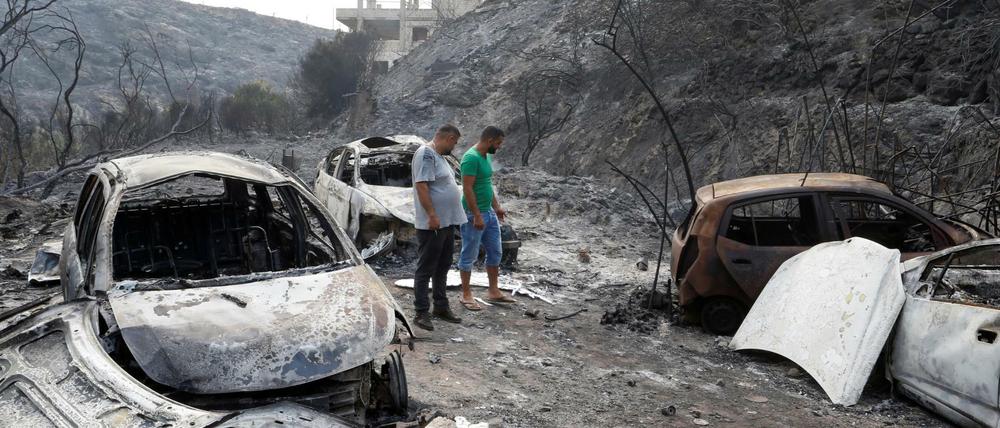 Anwohner begutachten ausgebrannte Fahrzeuge im Ort Damour südlich von Beirut. Ein Waldbrand war durch den Ort gezogen.