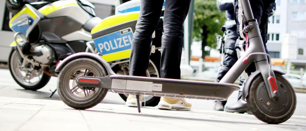 Polizisten kontrollieren in der Innenstadt von Düsseldorf einen E-Scooter-Fahrer